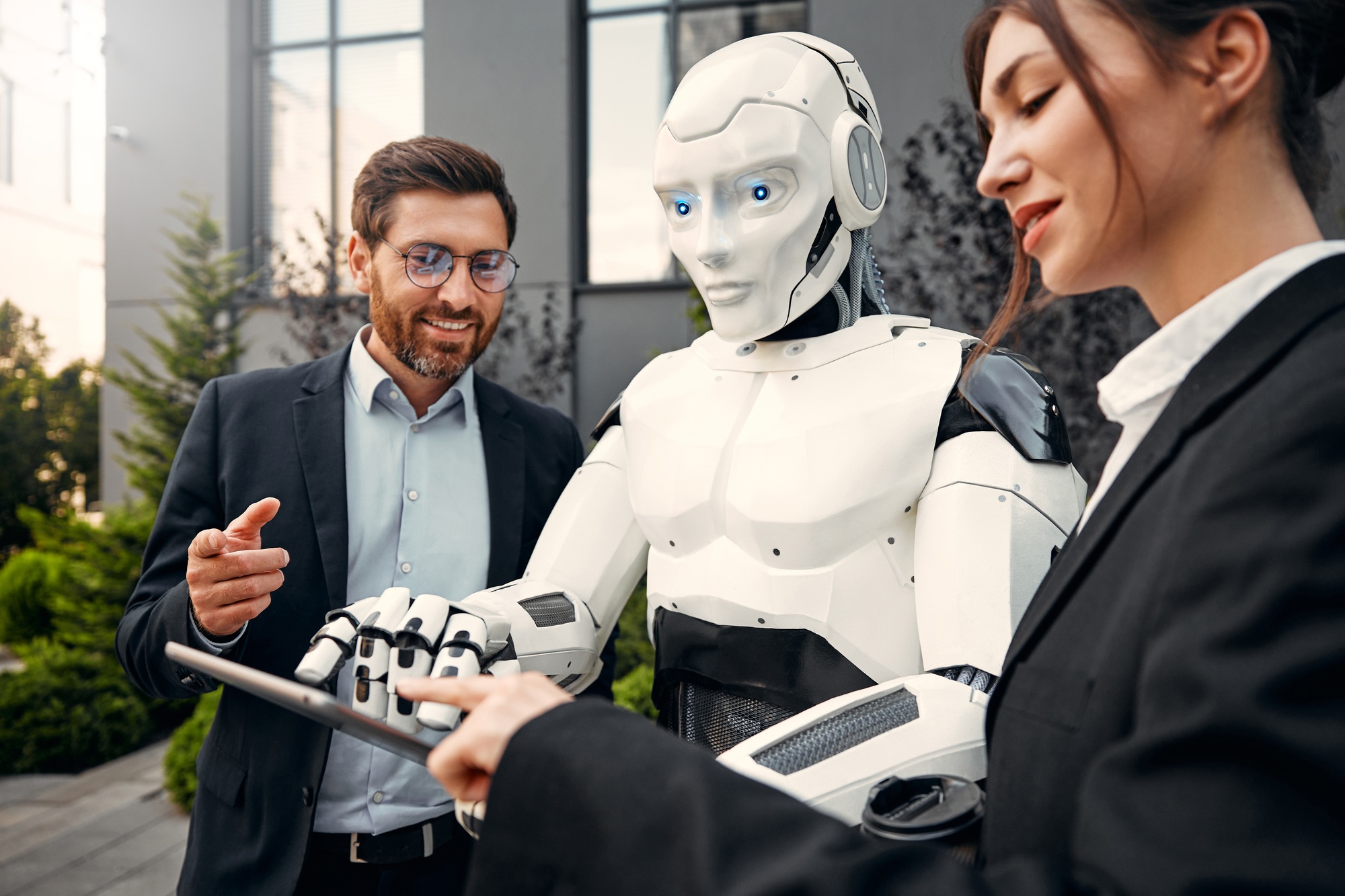 Robot with businessmen on the street near the building
